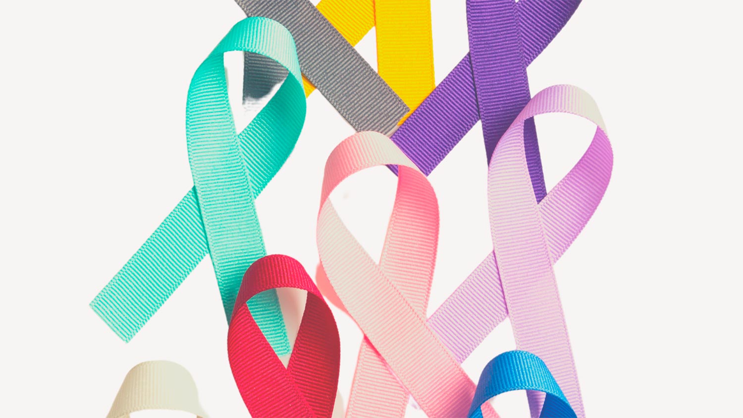 Tietoisuusnauhoja eri väreissä vaalealle taustalle levitettynä